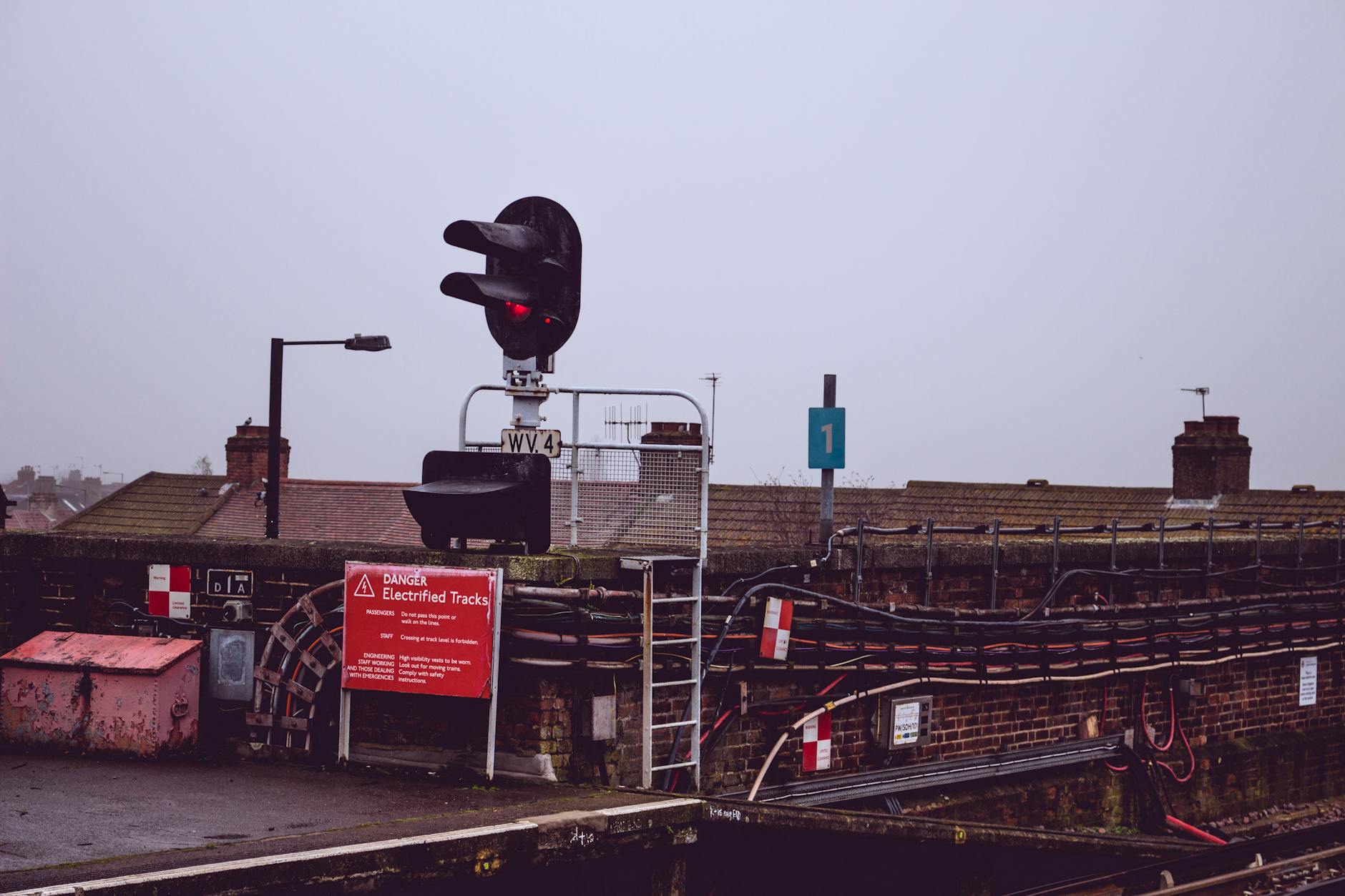 Czerwone światło sygnalizatora kolejowego na miejskim peronie