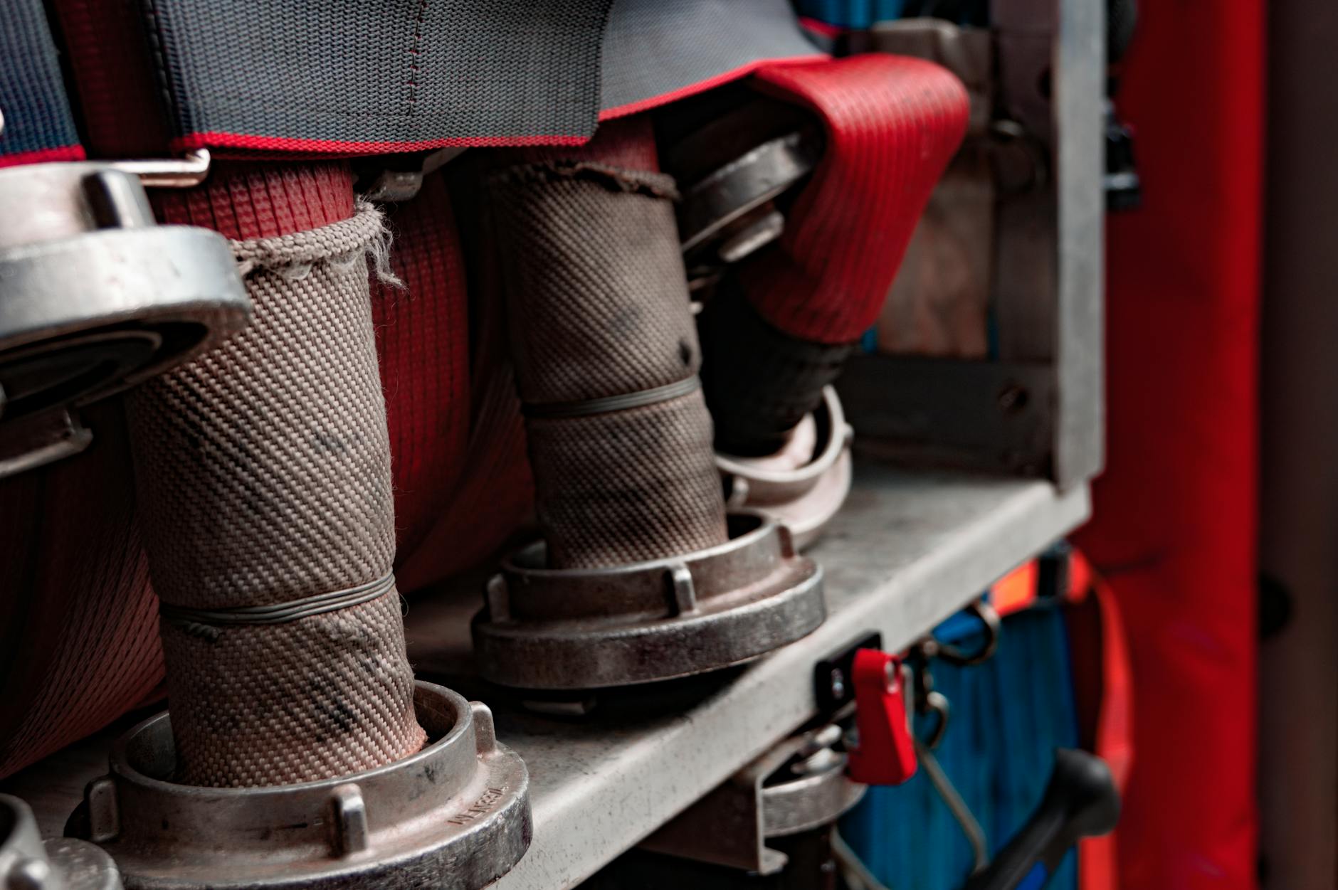 Zwinięte węże strażackie na półce wozu jako przykład systemu zraszania