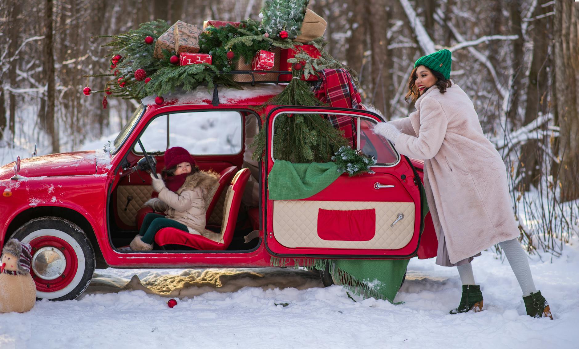 Mama i córka w aucie podczas zimowej podróży przez ośnieżony las