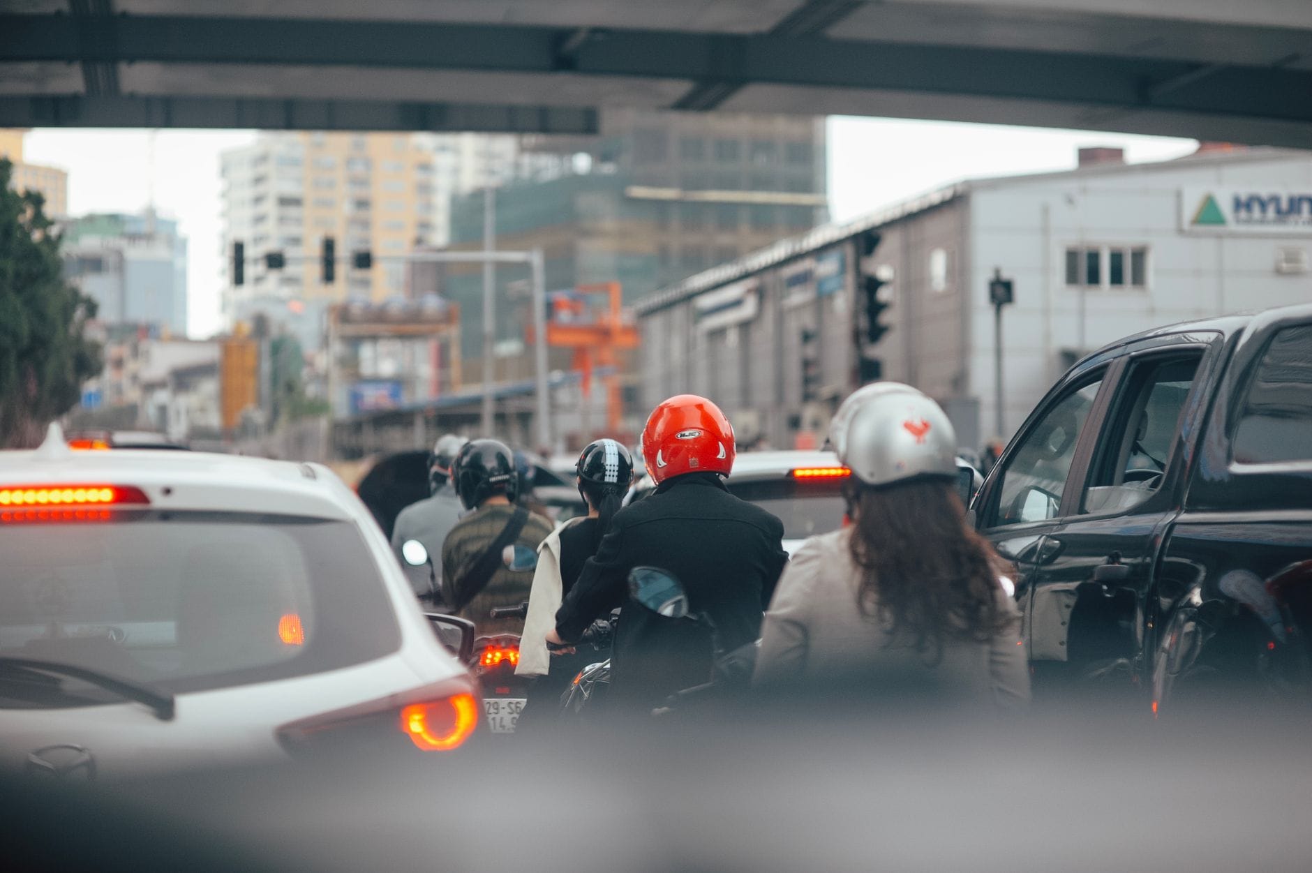 Motocykliści i auta stojące na światłach na miejskiej ulicy