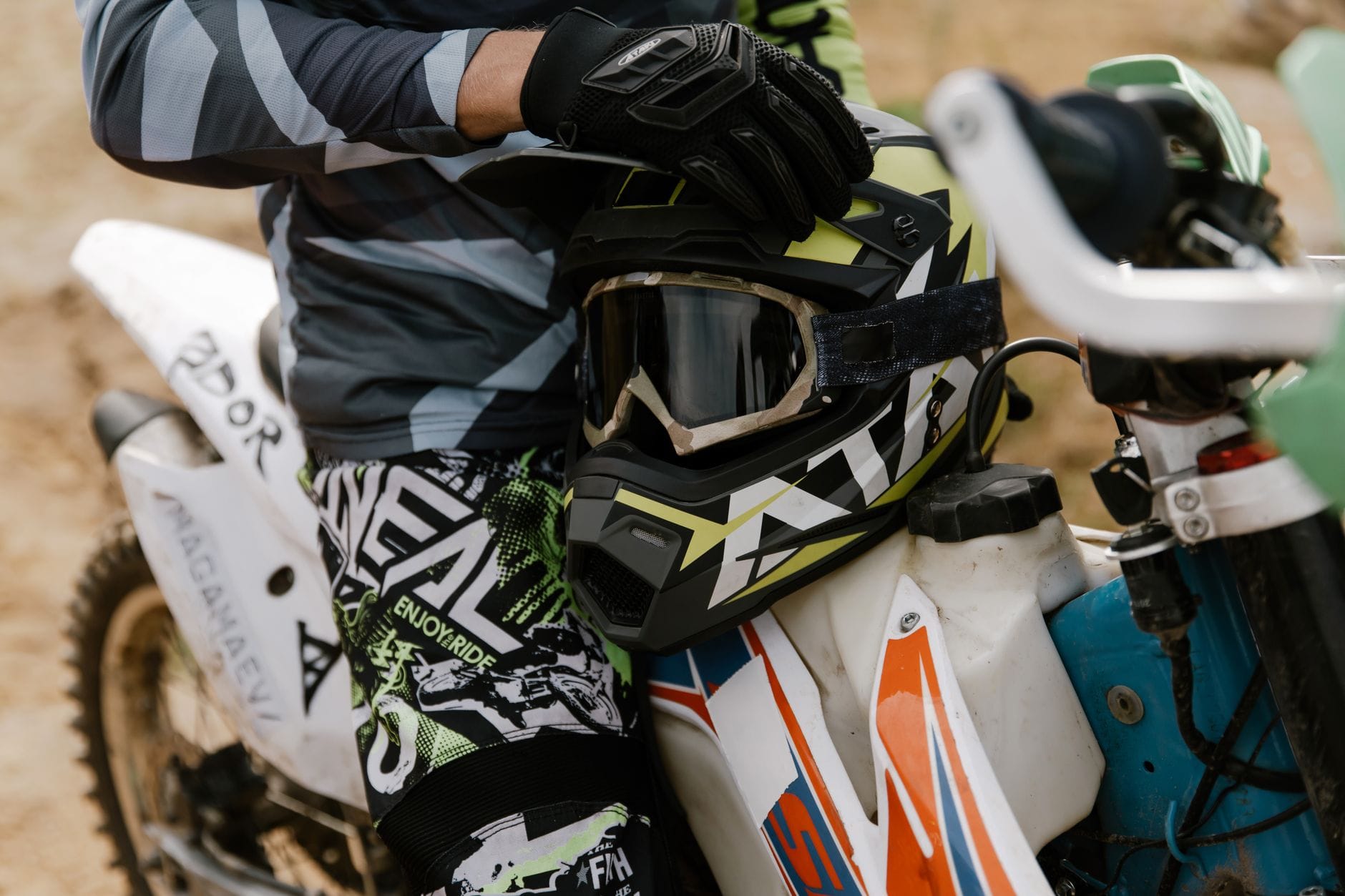 Motocyklista enduro z kaskiem przy crossowym motocyklu przed wyjazdem