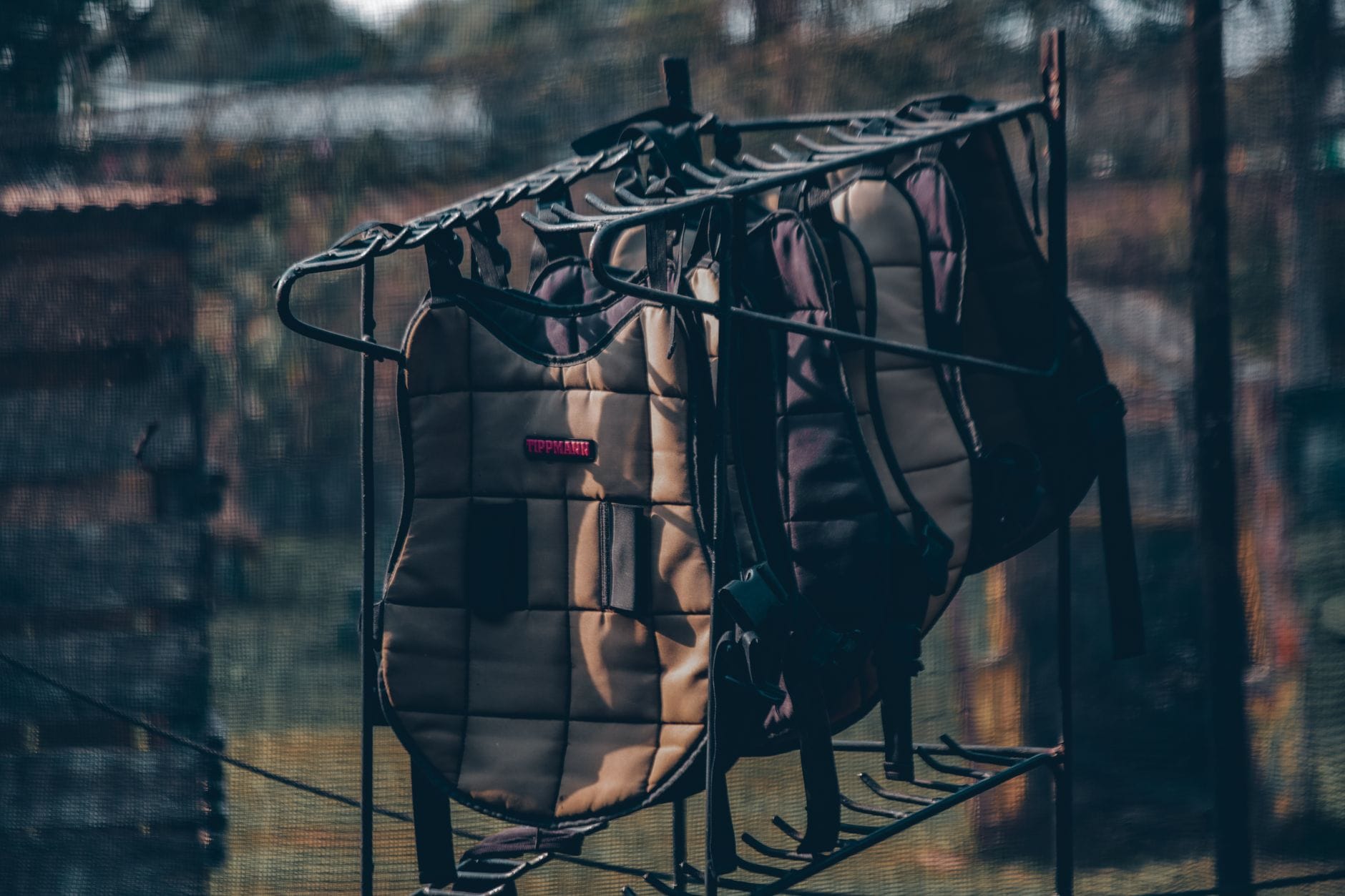 Sprzęt ochronny do paintballa wiszący na stojaku na zewnątrz
